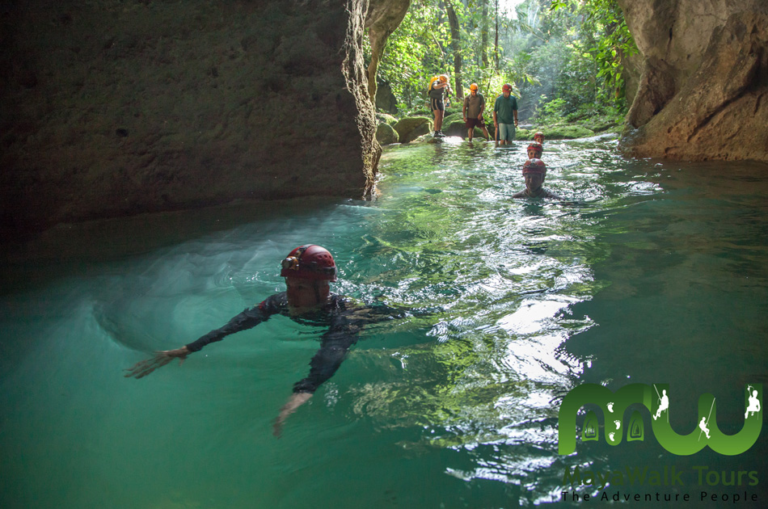 Entrance to Actun Tunichil Muknal ATM Cave in Belize surrounded by jungle Suggested image filenames if you have photos: atm-cave-belize-entrance.jpg, atm-cave-river-crossing.jpg, atm-cave-belize-guide.jpg (note: cameras/phones are banned inside the cave itself past the entrance pool, so any interior shots must be official/stock ones with credit, not yours)
